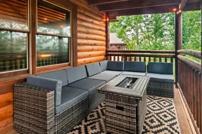 Screened-in lounge with plush sectional and fire table — the outdoor living room guests never want to leave. All the fresh air, none of the bugs.