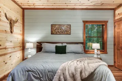 King bed against a crisp shiplap accent wall with warm lamp light flanking each side — the kind of bedroom setup that makes you genuinely look forward to bedtime.