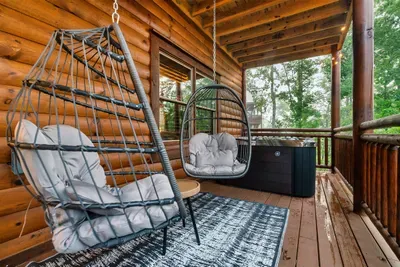 Hanging egg chair, private hot tub, and a covered deck canopy overhead — your after-hike ritual just got a serious upgrade. Settle in and don't move until dinner.