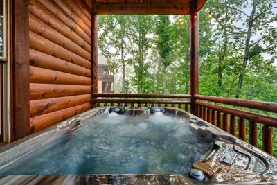 Private hot tub tucked against the log cabin walls with nothing but tree canopy above — soak under the stars while the Smokies go quiet around you. This is it.