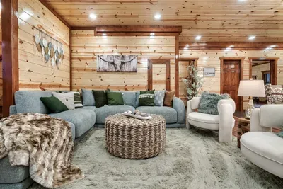 Fur throw draped across a plush sectional, warm lamp glow, and a longhorn presiding overhead — settle into this living room and the whole pace of life shifts down a gear.