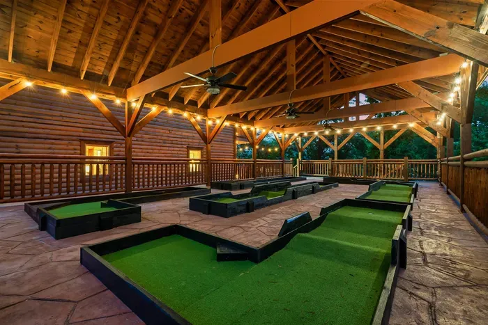 Nine holes of private mini golf under a handcrafted timber roof lit by warm string lights — bragging rights, rematches, and mountain air included with every round.