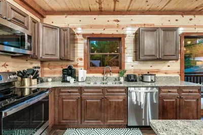 Generous counter space, full appliance suite, and a sink with treetop views — a kitchen that keeps up with whatever your group decides to cook up this trip.
