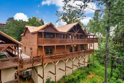 Multi-level cabin rising from the treetops — every deck a different view, every level its own retreat. This is what a group getaway is supposed to look like.