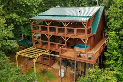 Multi-level decks wrapping the cabin, gazebo and slide below. Three floors of living space and outdoor room on every single one of them.