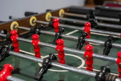 Foosball table with the rods spun and waiting. Fast games, loud rematches, and the one competition the kids usually win against the adults.