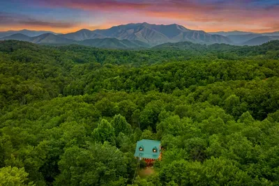 Aerial toward the high peaks with the cabin sitting quiet in the trees. Great Smoky Mountains National Park, 16.8 miles from your front door.