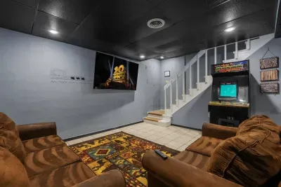 Sectional seating, TV, and an arcade cabinet in the corner. The rainy-day room that quietly turns into everyone's favorite part of the cabin.