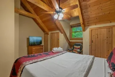Upstairs bedroom with its own TV and a window into the treetops. Where the teenagers claim their space and nobody has to negotiate over the remote.