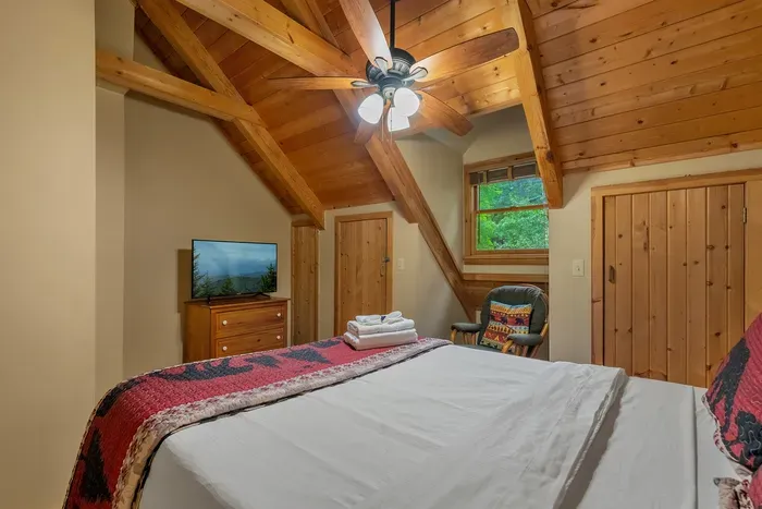 Upstairs bedroom with its own TV and a window into the treetops. Where the teenagers claim their space and nobody has to negotiate over the remote.