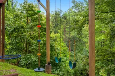 Tree swings and climbing ropes strung through the hardwoods. A backyard obstacle course in the forest — no screens required, no supervision needed.