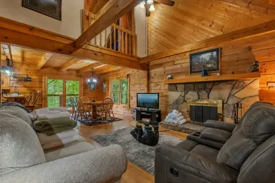 Windows full of green, seating for the whole crew. Real log construction with the warmth to match — this is the heart of the cabin every evening.