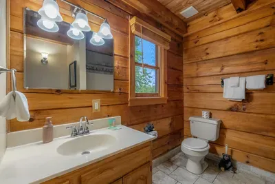 Full bath with a wide vanity and log walls — mountain character with modern fixtures. Plenty of counter space for a family getting ready all at once.