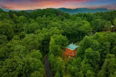 Aerial at dusk: one log cabin, unbroken forest, and not another building in sight. Private in a way most Smoky Mountain rentals only claim to be.