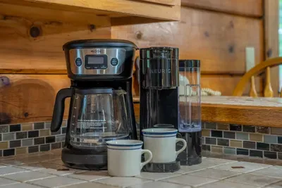 Coffee maker loaded and mugs waiting. Pour a cup, step onto the deck, and watch the mist burn off the ridge before anyone else in the cabin is up.