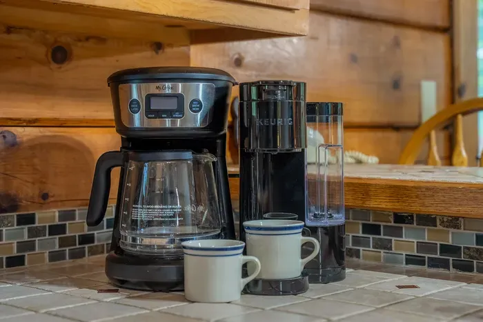 Coffee maker loaded and mugs waiting. Pour a cup, step onto the deck, and watch the mist burn off the ridge before anyone else in the cabin is up.