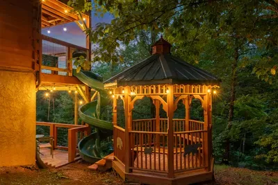 The gazebo lit up after dark, slide curling into the shadows. Bring a flashlight, chase the kids around, and let the evening run a little long.