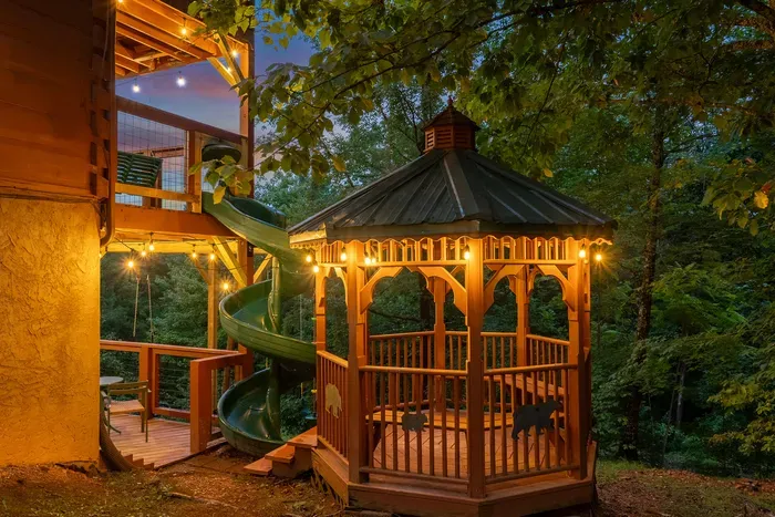 The gazebo lit up after dark, slide curling into the shadows. Bring a flashlight, chase the kids around, and let the evening run a little long.