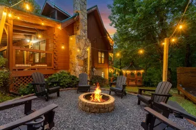 Fire pit burning at dusk with chairs pulled in close and string lights overhead. The gathering spot every night, no matter what the day's plan was.