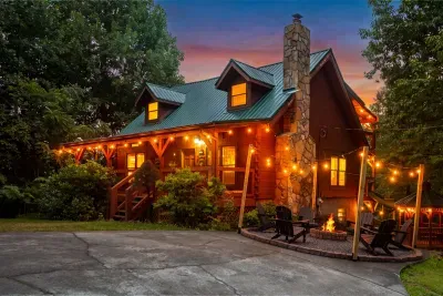 Dusk settling in with the cabin lit up and the fire pit ready. Pull in, drop the bags, and let the mountain evening take over from there.