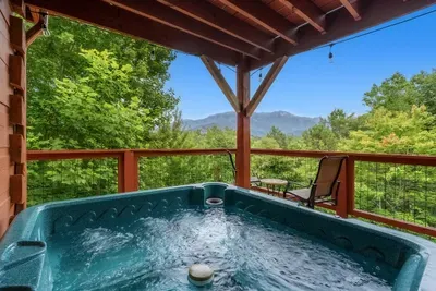 Hot tub on the deck with mountain views straight ahead. Jets on, sky turning, the Smokies going quiet all around you. The reason people rebook.