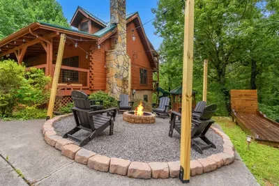 Stone fire pit ring with Adirondacks on a paved patio. Level, easy to reach, and steps from the door — bonfire night without hauling wood uphill.