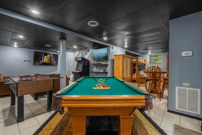 Pool table, dartboard, and big screen in the lower-level game room. Where the tournament starts after dinner and somehow keeps running until well past everyone's bedtime.