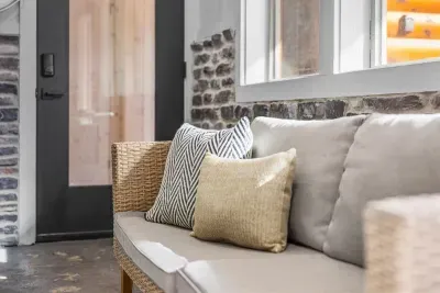 Relax on the sun porch with cozy seating and natural light all around.
