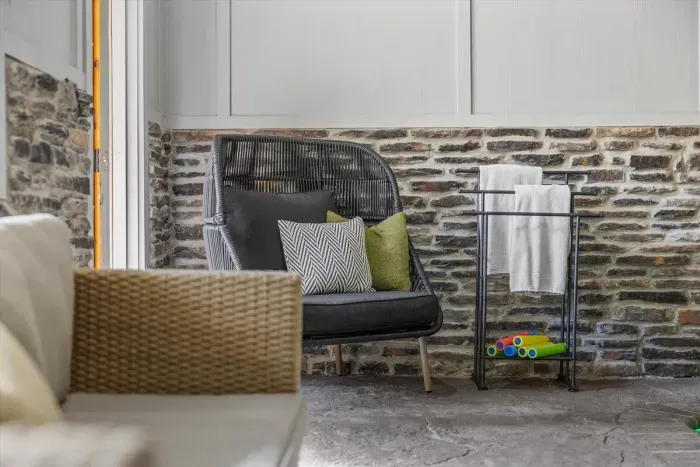 Cozy corner with plush pillows and modern stone accents — the perfect spot to relax after a swim.