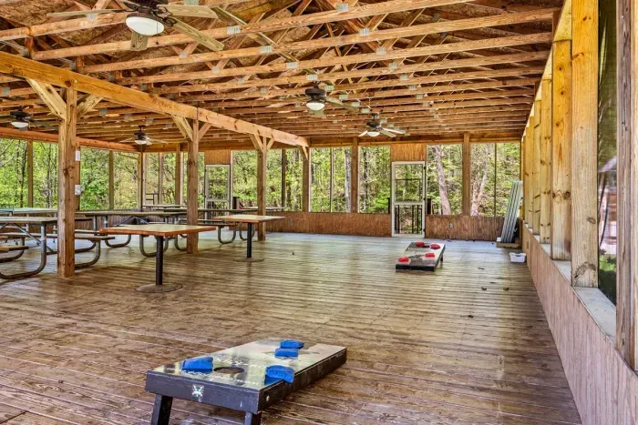 Community pavilion that includes picnic tables, yard games, and charcoal grills.