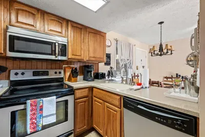 Kitchen with a view of the dining room includes coffee maker and toaster.