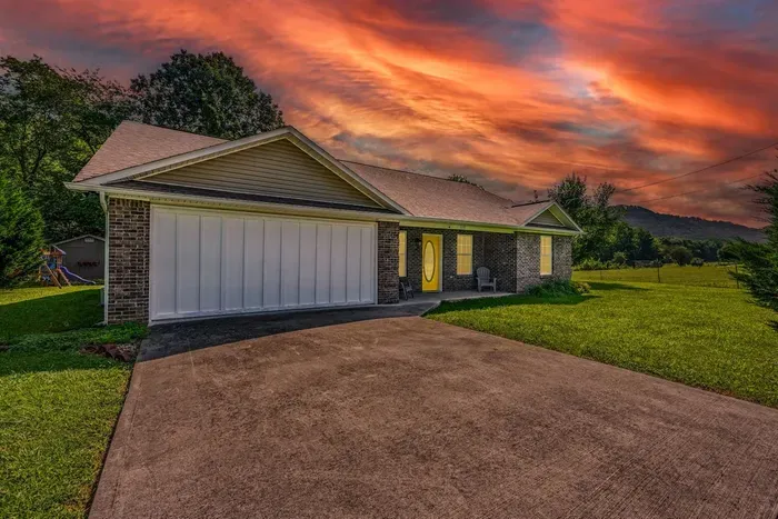 Brick exterior, two-car garage, mountain backdrop, and a kids' playset tucked in the yard — your home base arrives with more than you expected, right from the driveway.