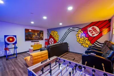 Theater recliners, foosball, a giant smart TV, popcorn machine stocked and ready, and RGB mood lighting — movie night here isn't an activity, it's an event.