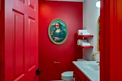 Strong color, simple comfort, a red wall bathroom with modern charm.
