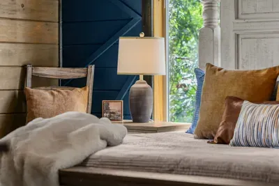 Soft textures and windows toward the trees add an extra layer of calm to the primary bedroom.
