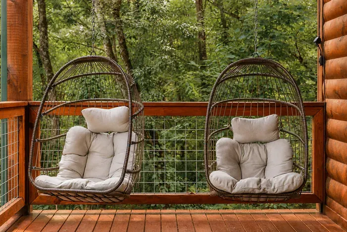 Two cushioned hanging chairs on the lower balcony—an easy spot for coffee, conversation, or a quiet break.