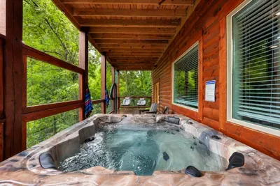 A second look at the private hot tub, tucked beneath the covered deck and surrounded by trees.