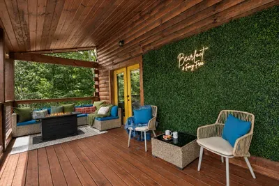 A greenery wall, comfortable seating, and forest views give this covered balcony its own tucked-away feel.