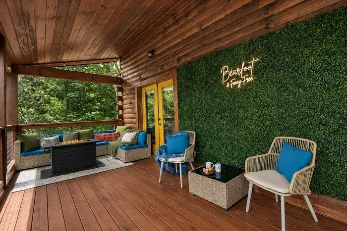 A greenery wall, comfortable seating, and forest views give this covered balcony its own tucked-away feel.