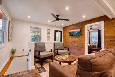 A second living area upstairs — armchairs, a soft sofa, and room to sprawl. One group can watch a movie downstairs while the rest settle in up here.