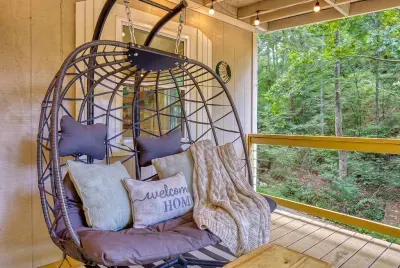 The hanging egg chair guests never want to give up. Wrap in the throw, crack your book, and let the forest hum through the screens — the best seat in the cabin, hands down.