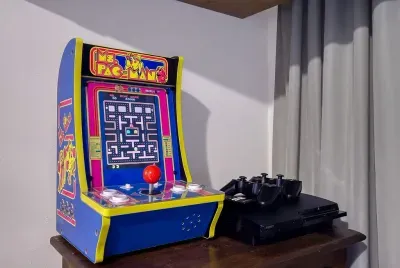 Ms. Pac-Man arcade cabinet, free play, no quarters needed. Loser makes the s'mores — the game room rivalry starts here and runs all weekend.