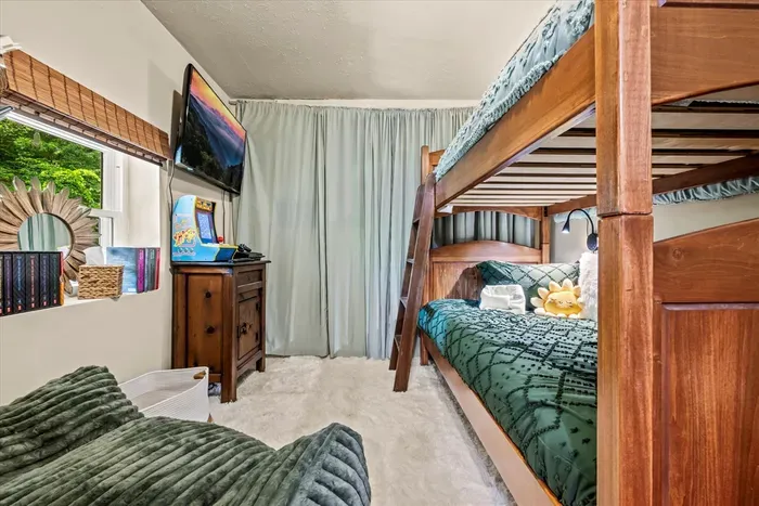 Second bunk room with a smart TV, solid wood bunks, and its own window on the woods. Sleeps the cousins, the teens, or anyone who claimed the top bunk first.