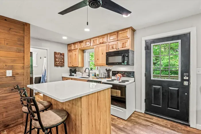 Fully stocked kitchen with island seating for four, full-size appliances, and a back door straight to the deck. Cook big, eat together, then take dessert outside.
