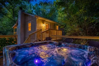 Hot tub glowing under the stars with color-changing lights and the cabin warm behind you. Jets humming, cool air on your face — this is the photo you'll send home.