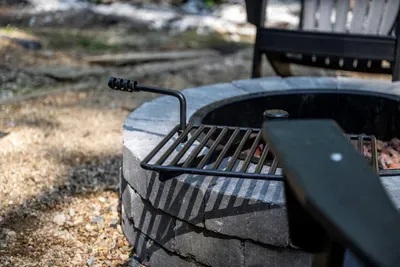 Fire pit with a swing-away grill grate — burgers over open flame, then s'mores when the coals settle. Firewood's on site, so all you bring is the marshmallows.