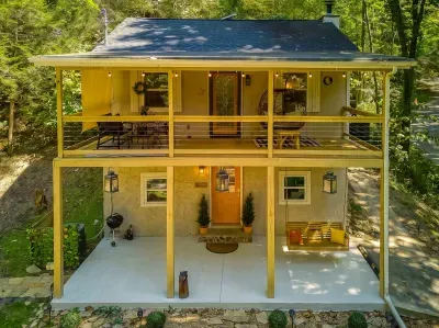 Two levels of covered porch, both lit and furnished — rockers up top, dining and grill below. Twice the outdoor living, whatever the mountain weather decides to do.