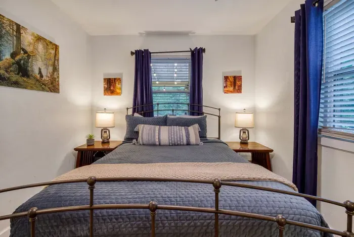 Handcrafted iron bed, blackout curtains, and a quiet that only mountain mornings deliver. Lamp-lit nightstands on both sides means nobody has to get up to flip the switch.