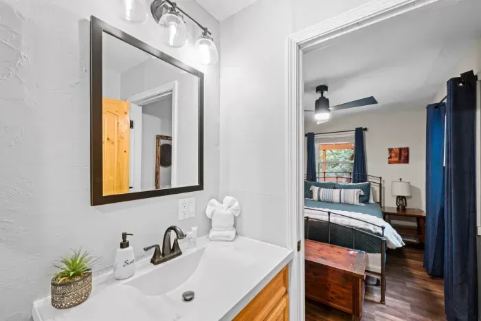 Vanity with wide counter space and a bath that opens right into the bedroom. Fresh towels stacked, lighting that's actually good, and no waiting in line in the morning.
