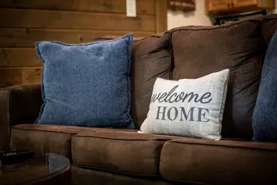 Welcome home — the pillow means it. Deep cushions, soft throws, and a couch that's held more naps than anyone will admit. Settle in, you've officially arrived.
